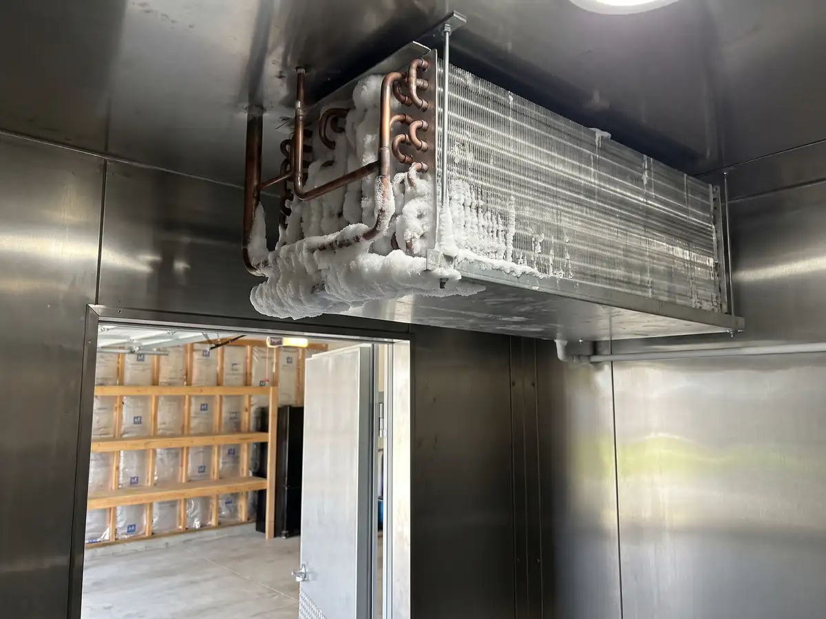 An evaporator coil iced over above the door of a walk-in cooler
